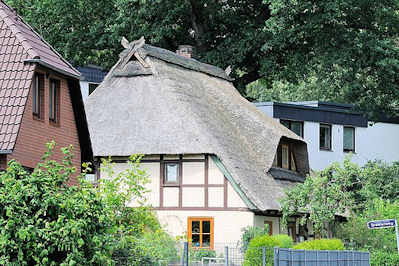 7363 Reetdachgebude mit Fachwerkmauern zwischen neuerrichteten Einzelhusern im Hamburger Stadtteil Eiendorf.
