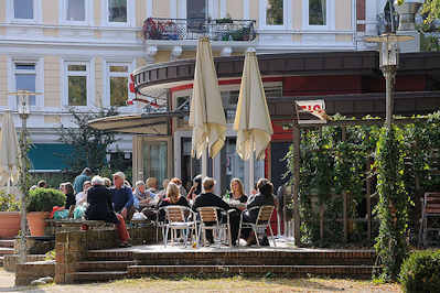 8103 Strassencafe in der Sonne - Gste sitzen in Hamburg Ottensen an der Eulenstrasse.