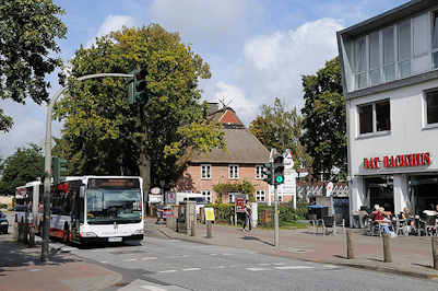 7263 Linienbus 5 der HVV Richtung Hamburger Innenstadt / ZOB in der Frohmestrasse. Reetdachhaus und Geschfte in der Schnelsener Hauptverkehrsstrasse.